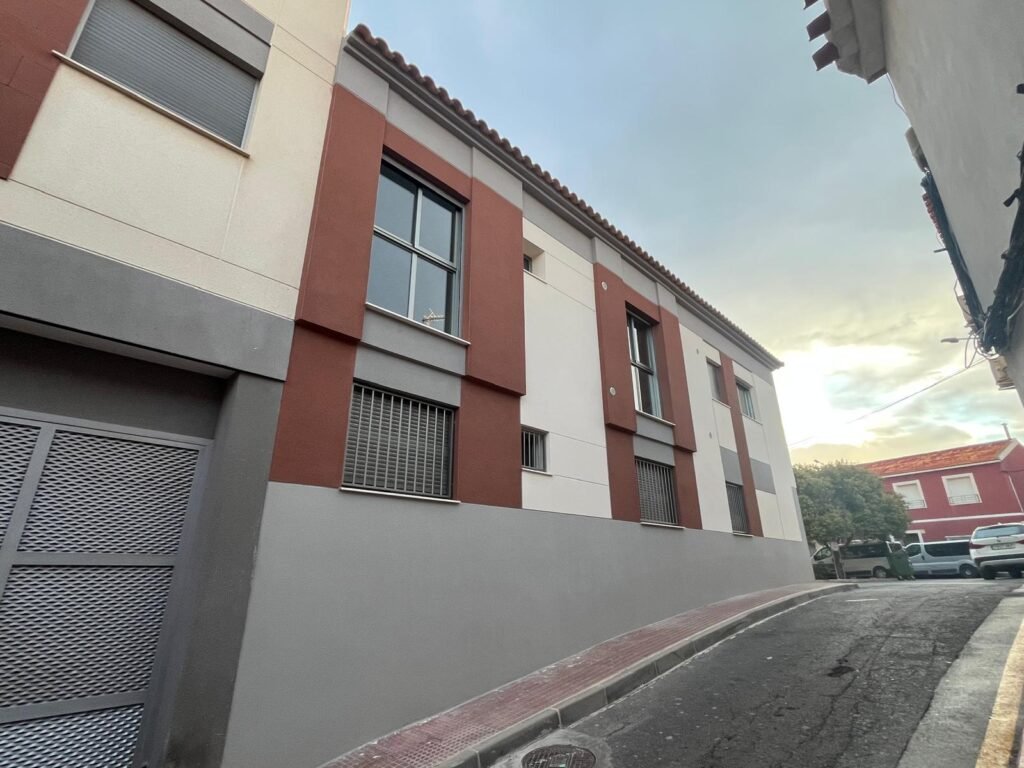 Fachada lateral de vivienda con diseño moderno en zona residencial.